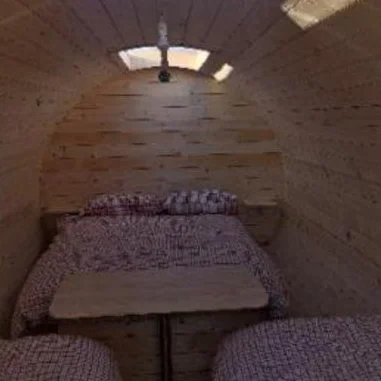 Inside a Low Road Nursery glamping pod with double bed and table